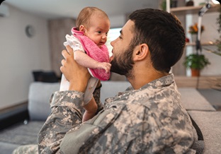 Military father looking baby in eyes